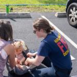 HFD member Leslie Pullen assists a community member with a car seat safety check. A recent VDH grant will support HFD's efforts to conduct more child safety activities in Harrisonburg