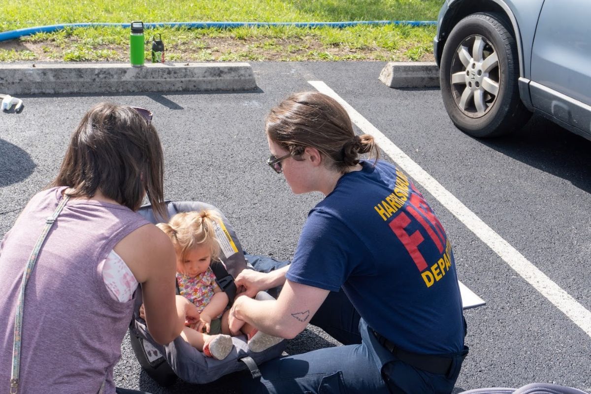 HFD member Leslie Pullen assists a community member with a car seat safety check. A recent VDH grant will support HFD's efforts to conduct more child safety activities in Harrisonburg