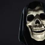 Up close of a fake skeleton with a black hood.