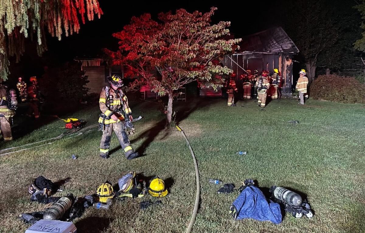 Firefighters outside of a house on fire