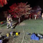 Firefighters outside of a house on fire