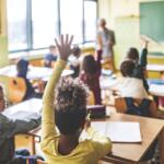 Students raising their hands in a classroom