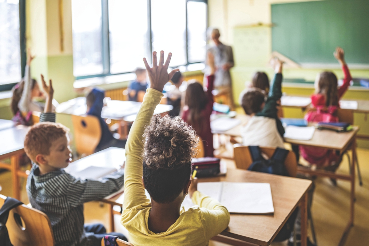 Students raising their hands in a classroom