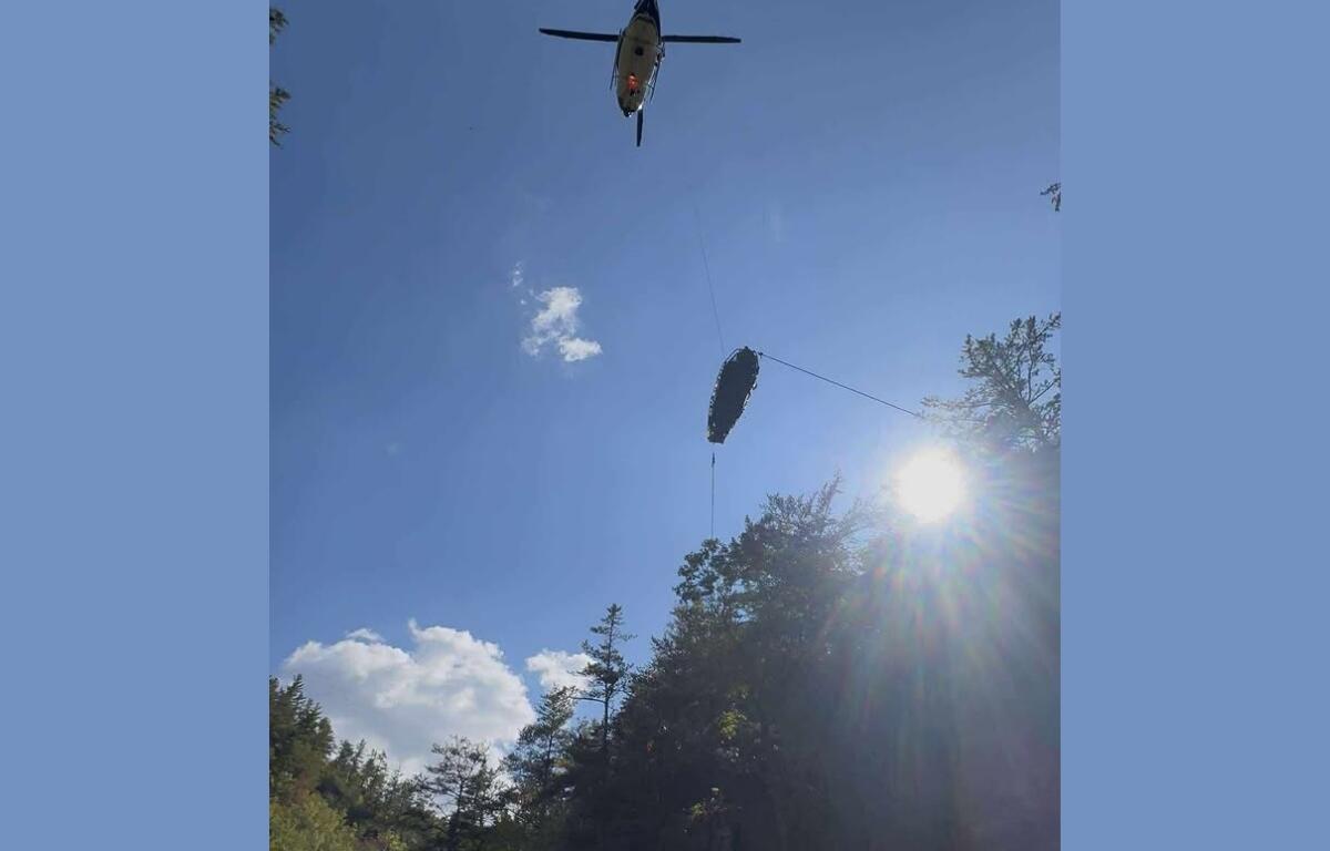 A helicopter raises the woman out of