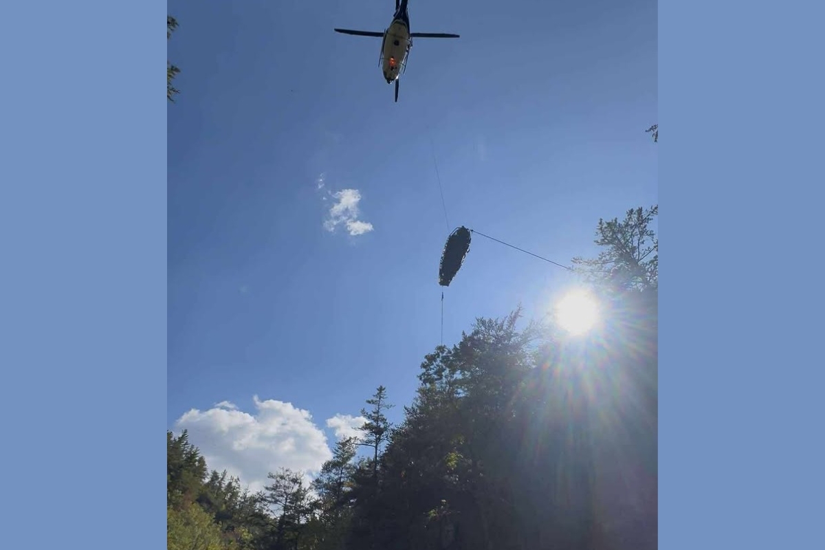 A helicopter raises the woman out of