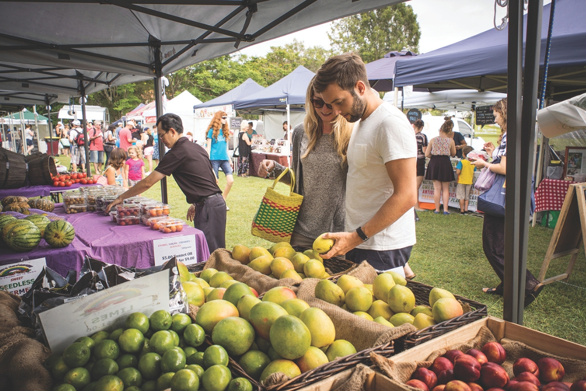 People browse produce at a farmers market.