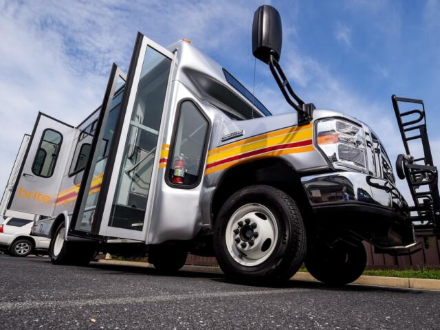A brite bus in a parking lot.