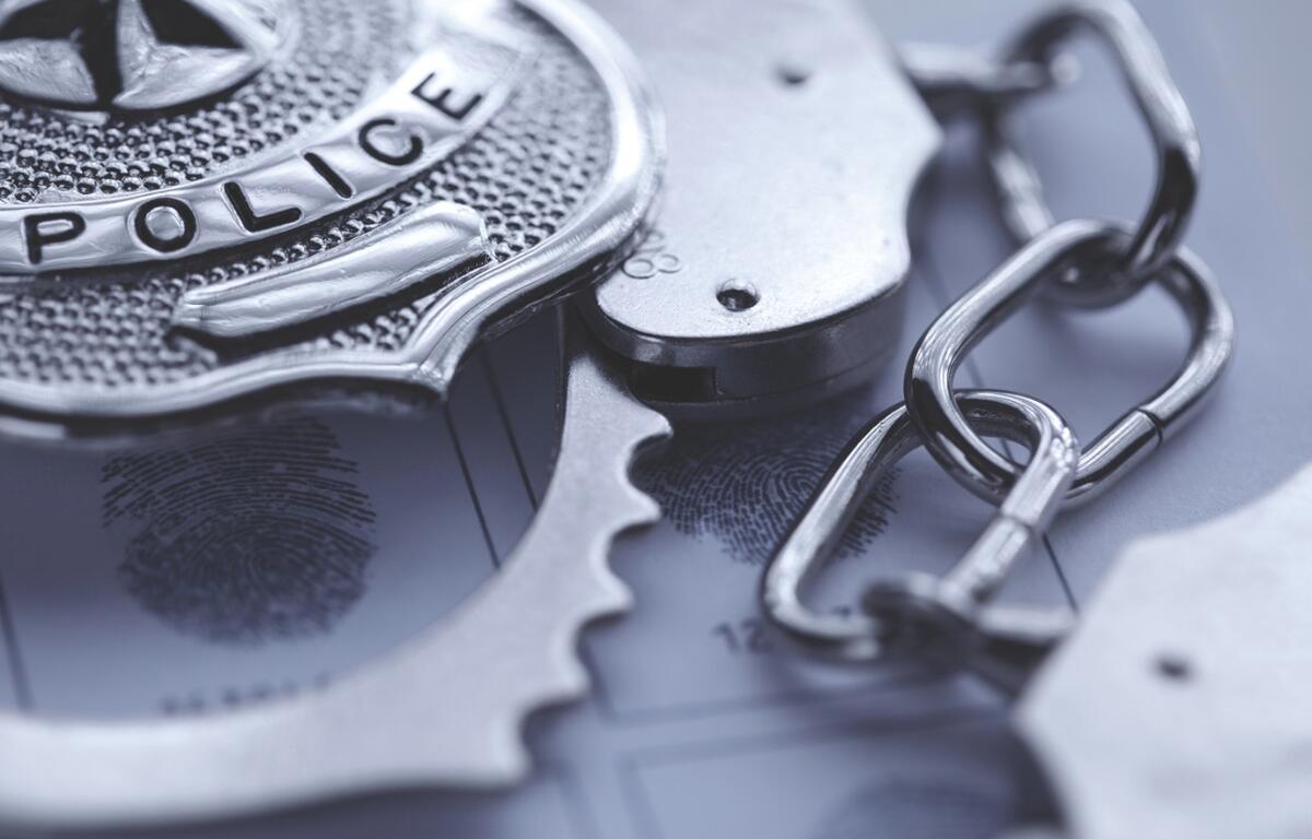Up close of a police badge and handcuffs.