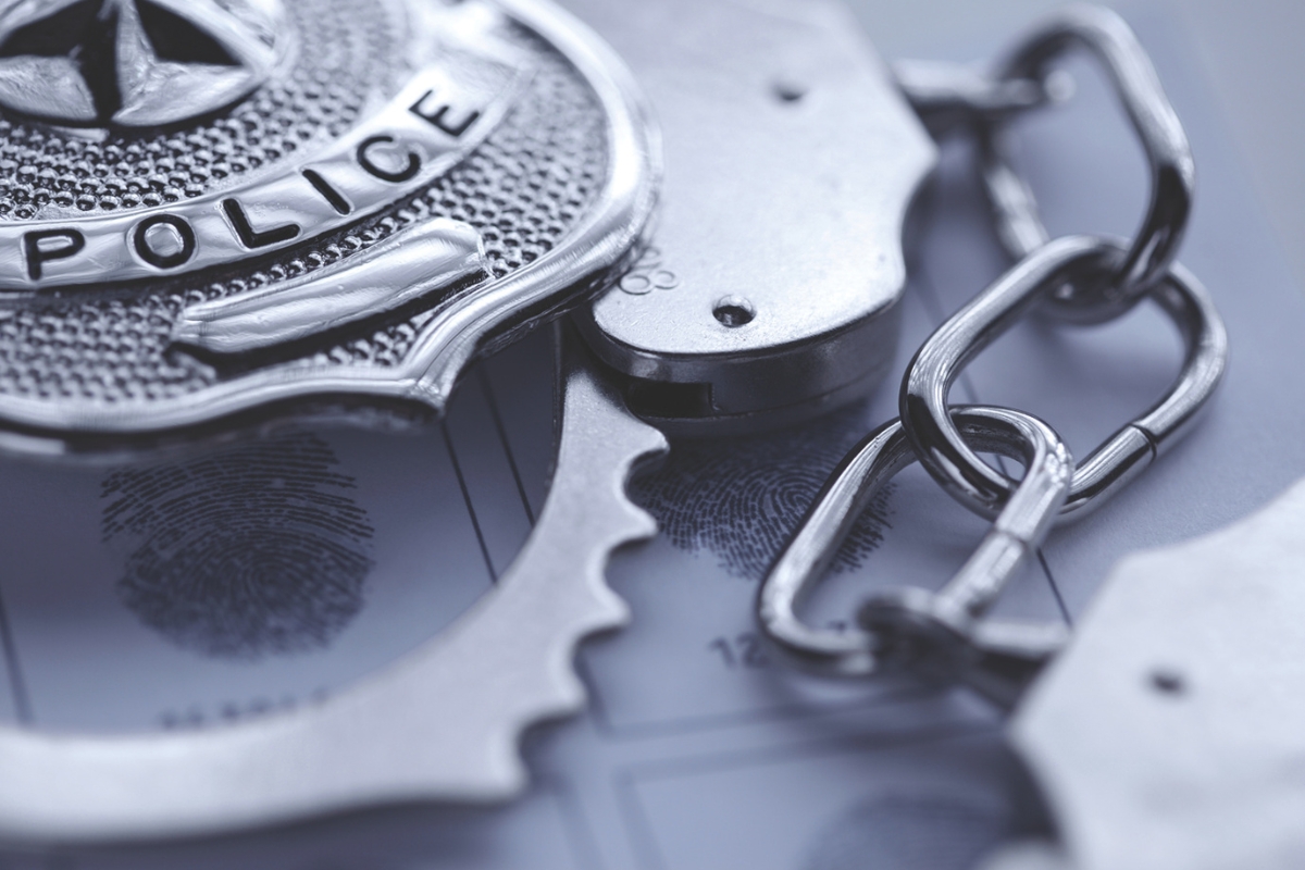 Up close of a police badge and handcuffs.