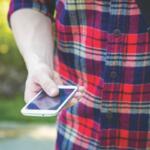 Man wearing a flannel and holding a phone