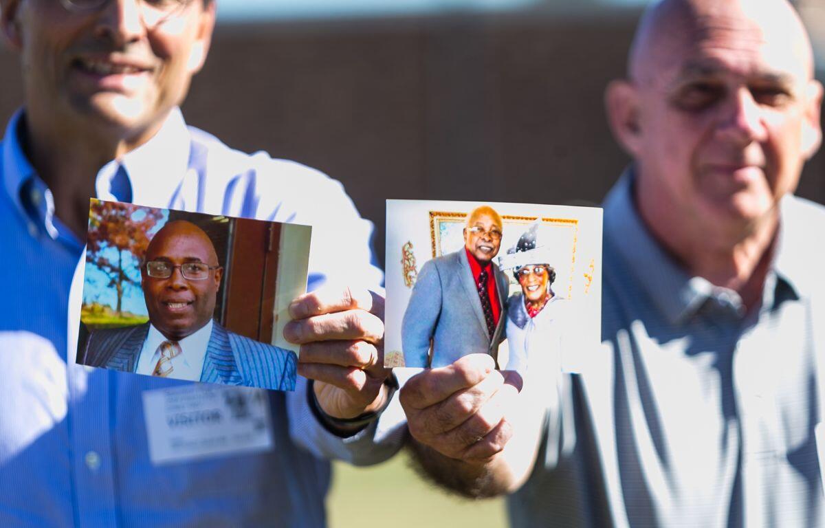 Jose Gomez, left, and John Woodrum hold up pictures of Tony Hamilton, left, and his parents Alphonso and Catherine "Kitty"Hamilton. 