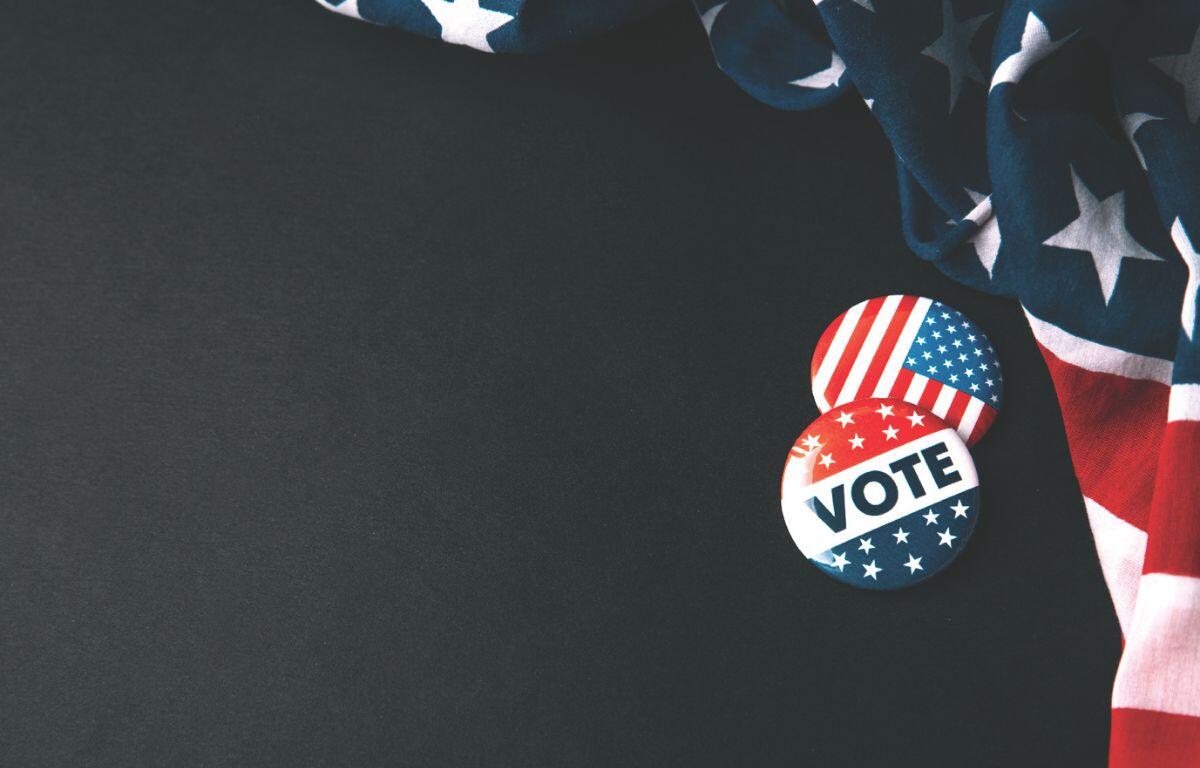 Vote pins next to American flag