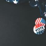 Vote pins next to American flag