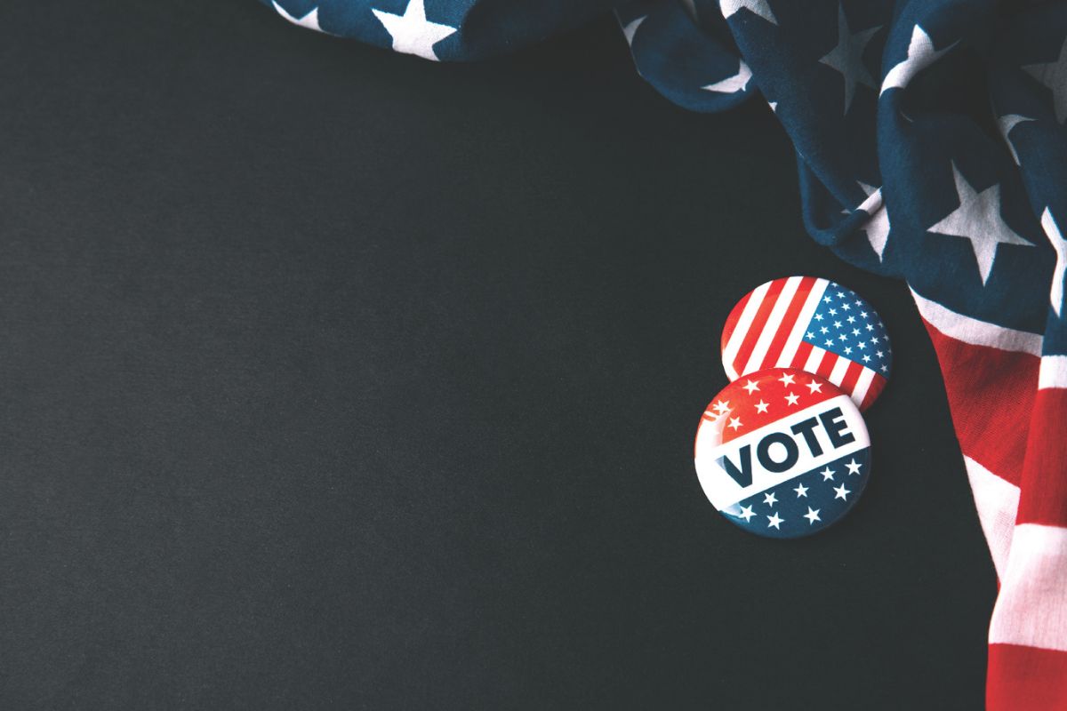 Vote pins next to American flag
