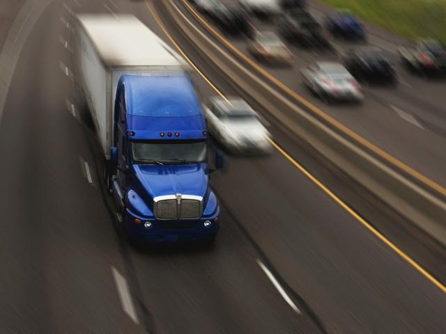 A semi truck on a busy interstate.