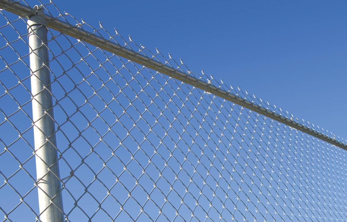 A chain-link fence against the sky.
