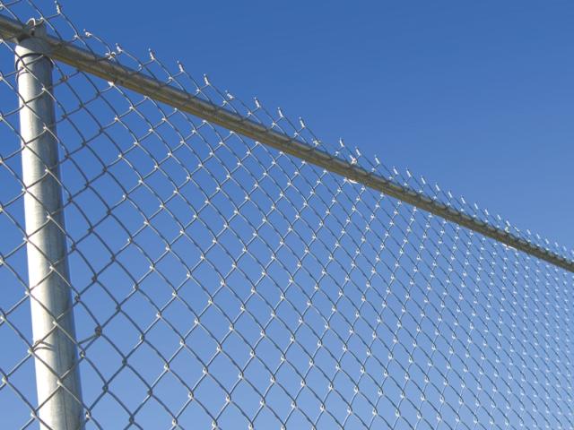 A chain-link fence against the sky.