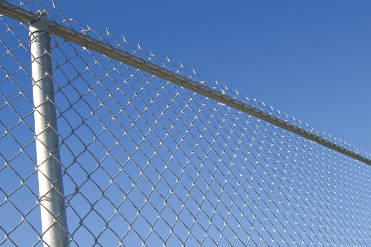 A chain-link fence against the sky.