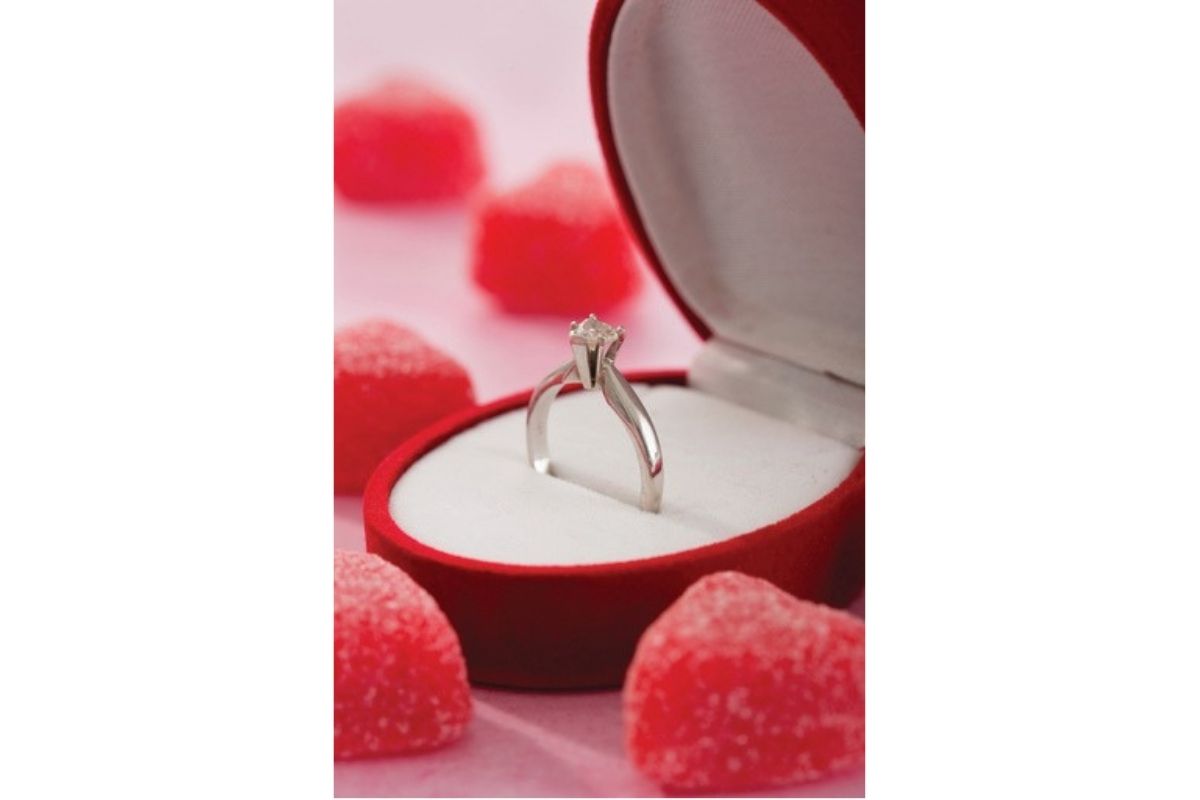 Engagement ring in a red box with a pink background