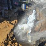 Public Works crews are repairing a break while water sprays them and freezes over the site.