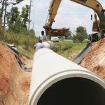 Workers replacing a pipeline in the ground.