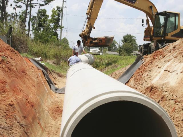 Workers replacing a pipeline in the ground.