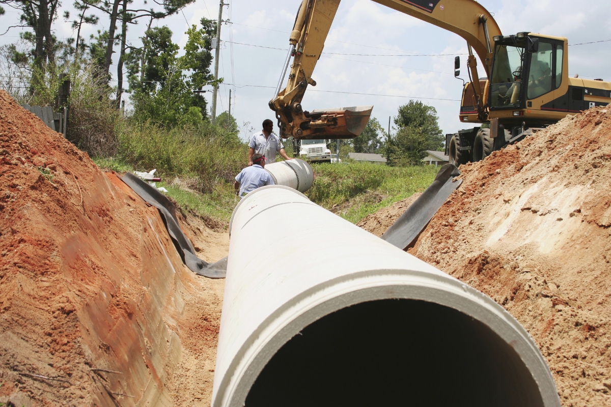 Workers replacing a pipeline in the ground.