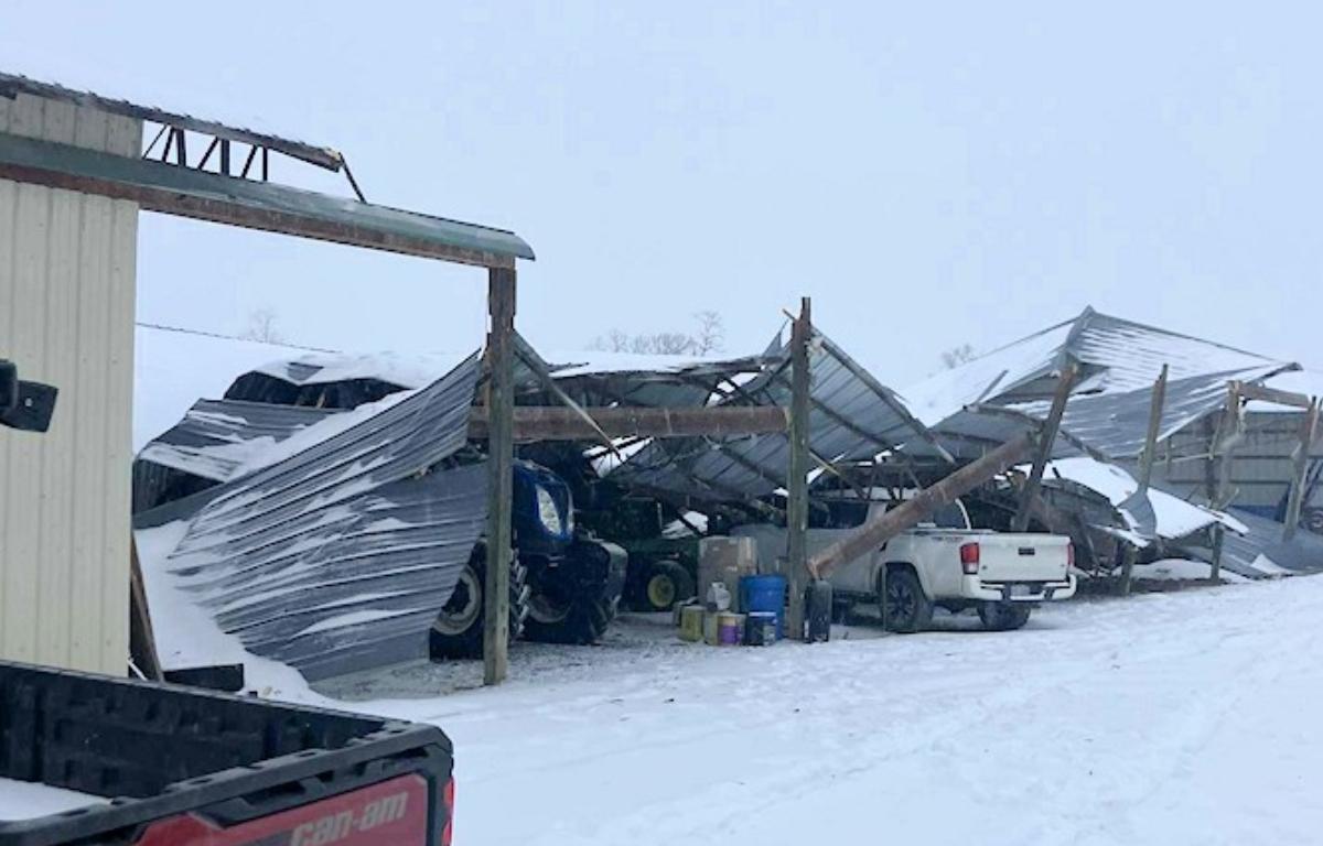 A collapsed barn over trucks.