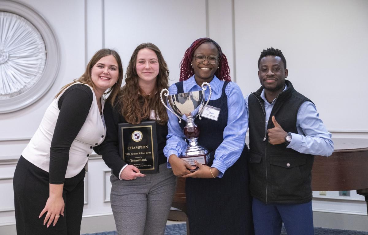 Ifeatu Udokwu, Laine Anthony, Madison Lizarraga, and Isaac Plange holding a plaque and trophy.