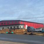An outside view of the new Harrisonburg Collision Center. A large red warehouse building.