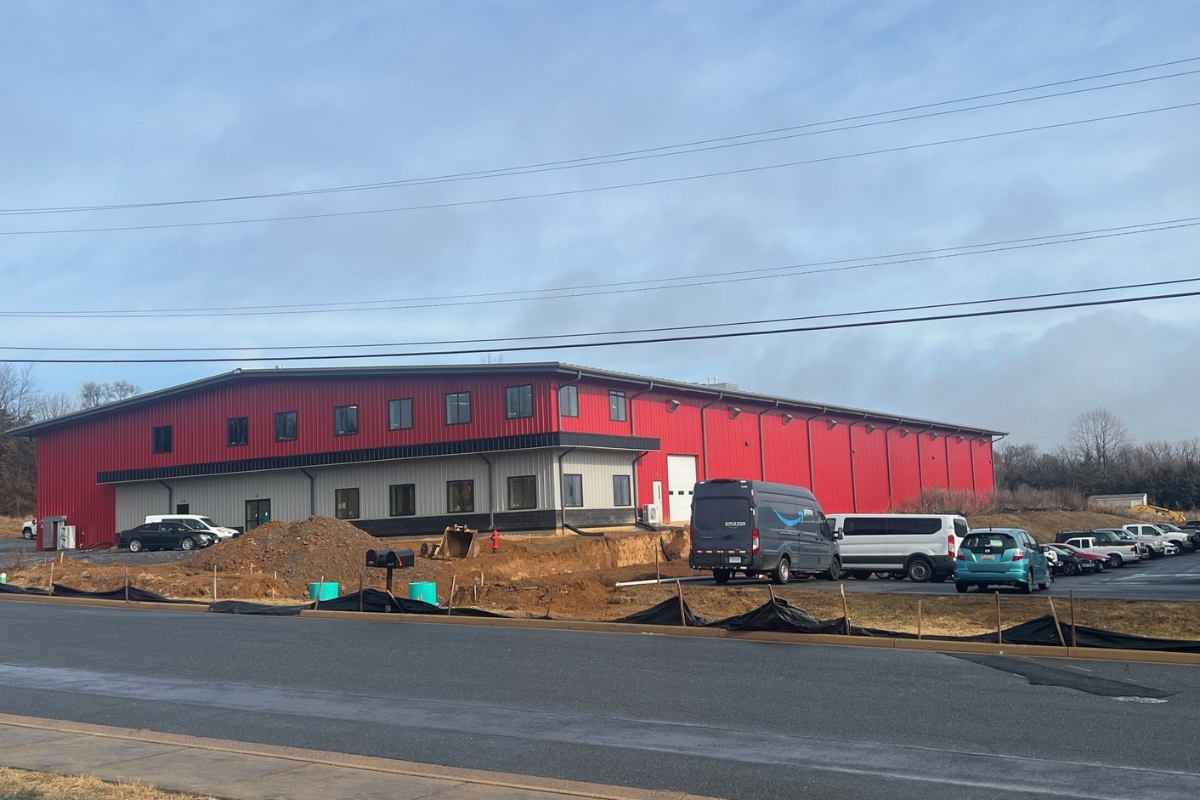 An outside view of the new Harrisonburg Collision Center. A large red warehouse building.