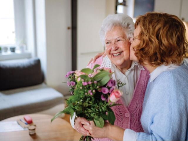Woman giving her mother flowers