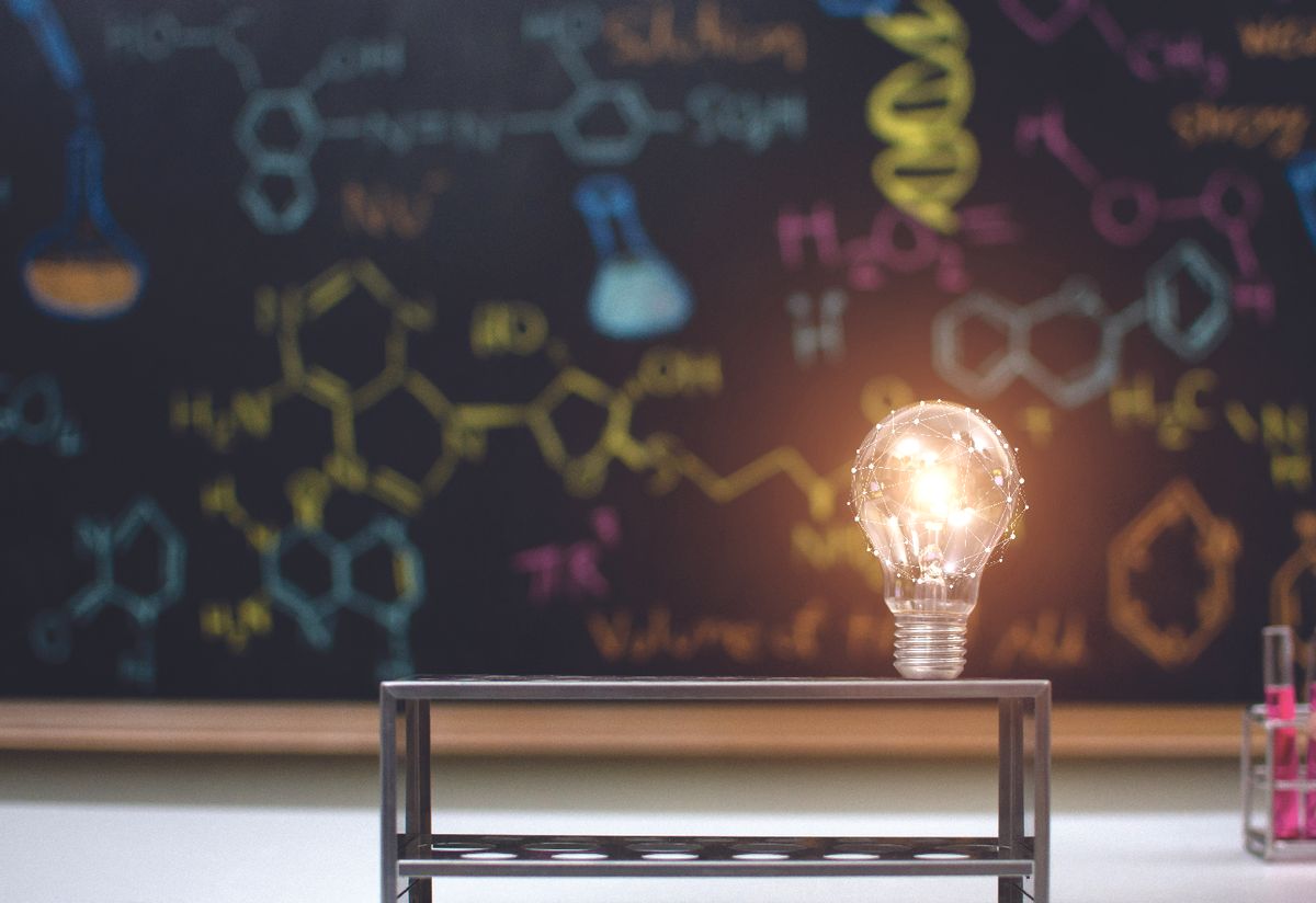 Lightbulb in front of a chalkboard