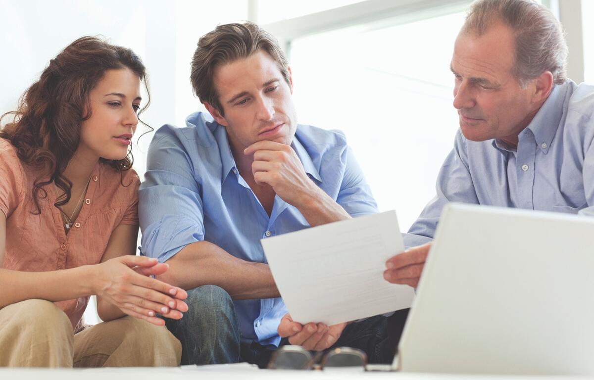 Three people looking at a piece of paper