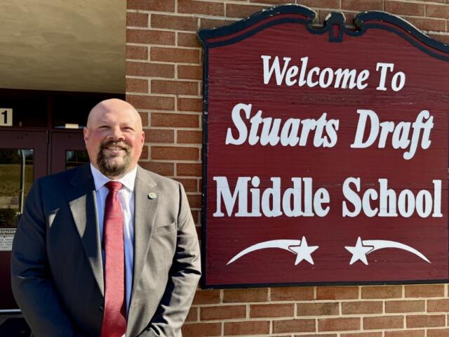 Steve Hom standing next to the Stuarts Draft Middle School sign.