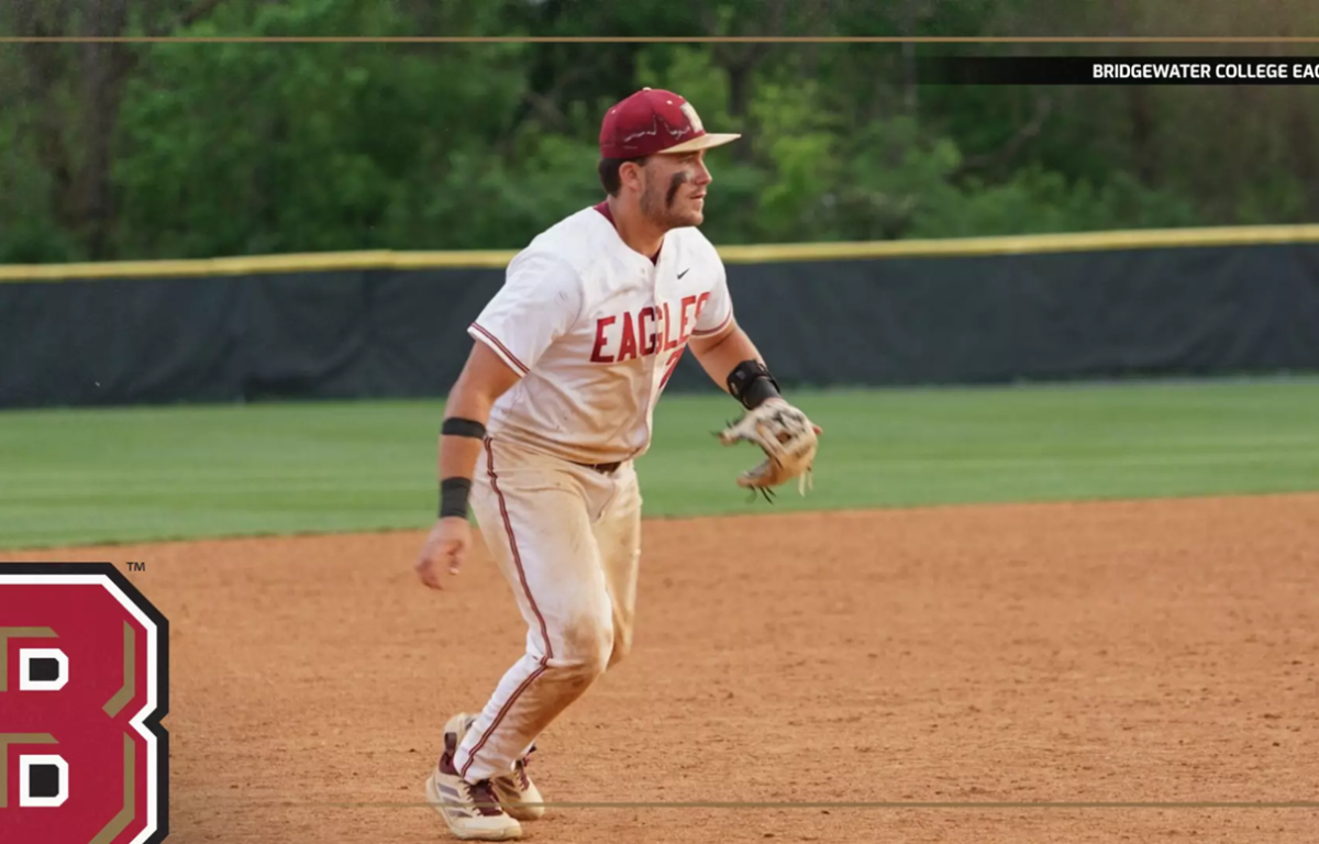 Baseball player in a white Eagles uniform on the infield, ready to field, with Bridgewater College Eagles branding visible.
