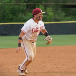 Baseball player in a white Eagles uniform on the infield, ready to field, with Bridgewater College Eagles branding visible.