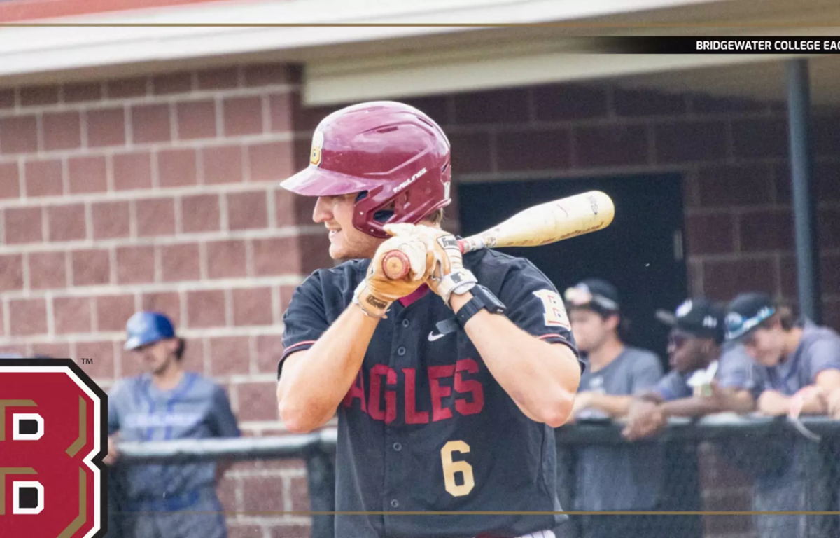 Baseball player in a maroon helmet and black Eagles jersey (number 6) holds a bat ready to swing at the plate.