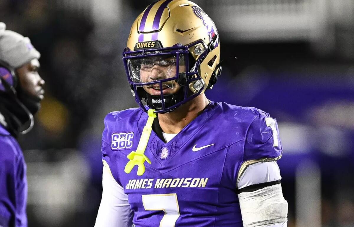 James Madison Dukes football player in a purple uniform and gold helmet wearing a yellow mouthguard, #7