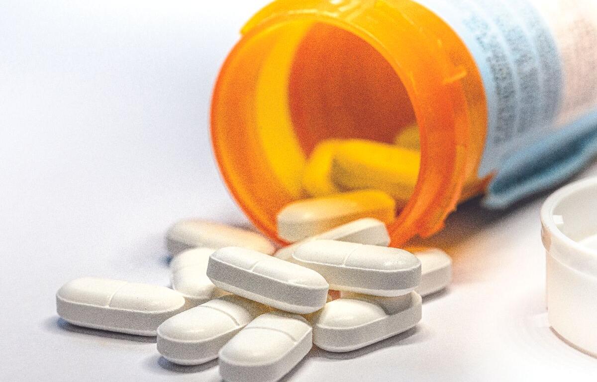 Closeup of white pills out of a pill bottle