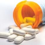 Closeup of white pills out of a pill bottle