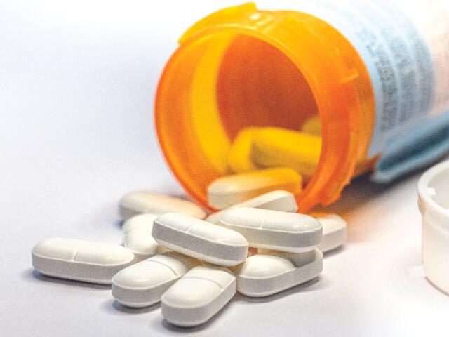 Closeup of white pills out of a pill bottle