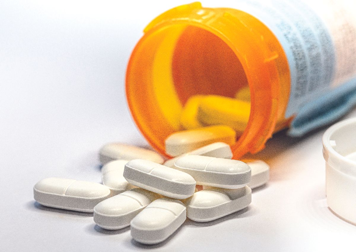 Closeup of white pills out of a pill bottle