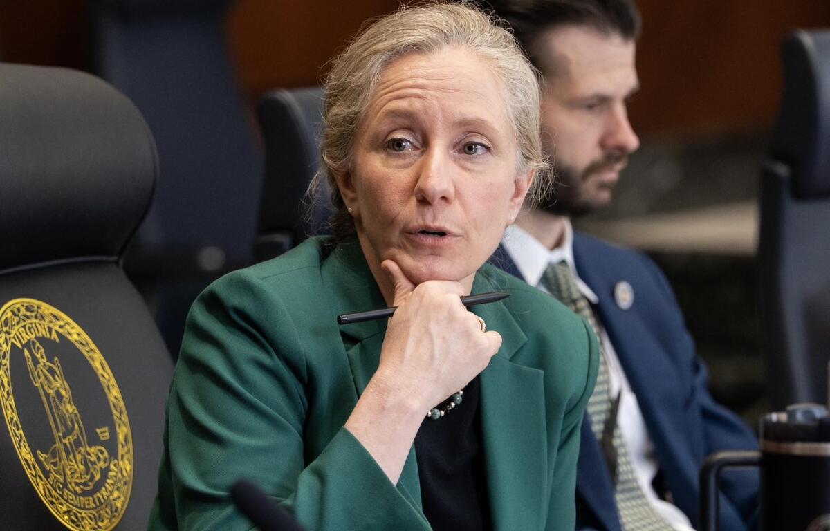 Spanberger sitting at a table with a pen.