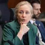 Spanberger sitting at a table with a pen.