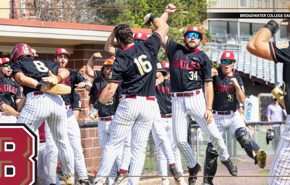 Bridgewater College Eagles baseball team celebrating a win with high-fives at the dugout, players in black jerseys and white pinstriped pants.