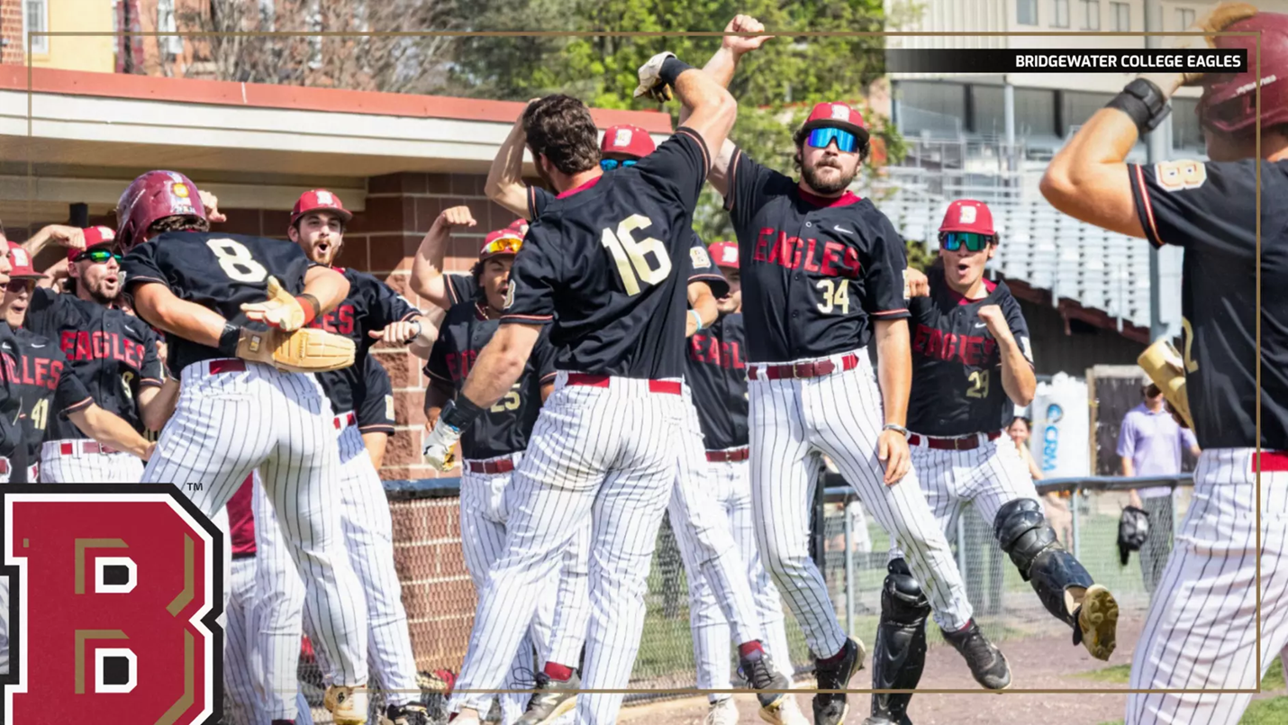 Bridgewater College Eagles baseball team celebrating a win with high-fives at the dugout, players in black jerseys and white pinstriped pants.