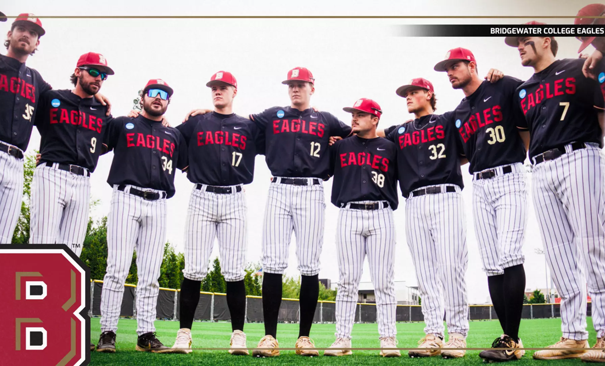 Bridgewater College Eagles baseball team stands in a line with arms around each other on the field, wearing black jerseys and pinstripe pants.