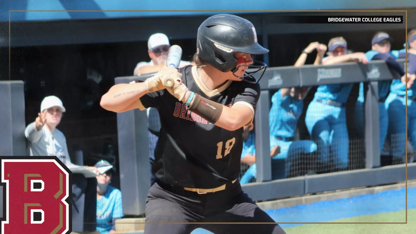 Baseball player in black uniform swinging a bat during a game, Bridgewater College Eagles on the jersey, crowd in the background.