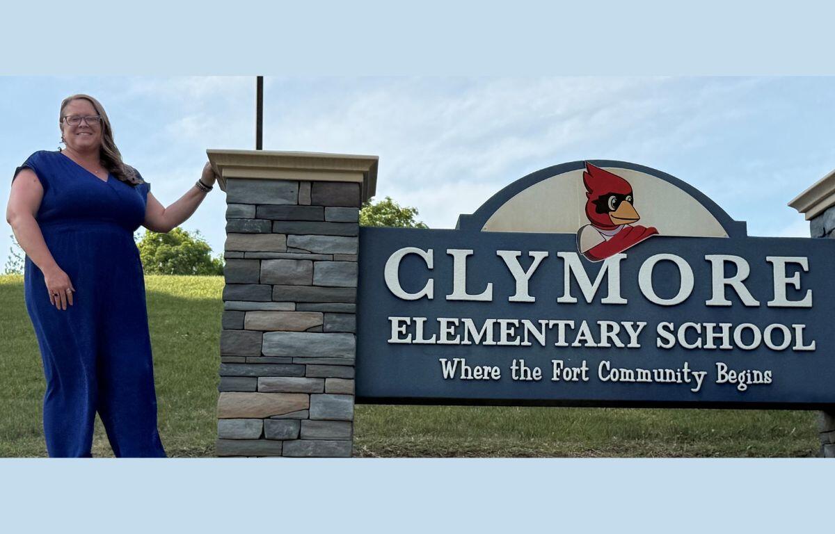 Carrie Barb in front of the Clymore Elementary School sign